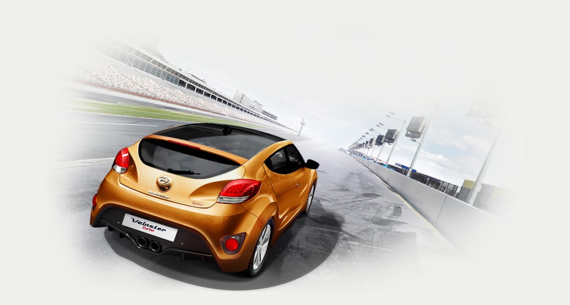 Rear view of tangerine car of driving Veloster Turbo