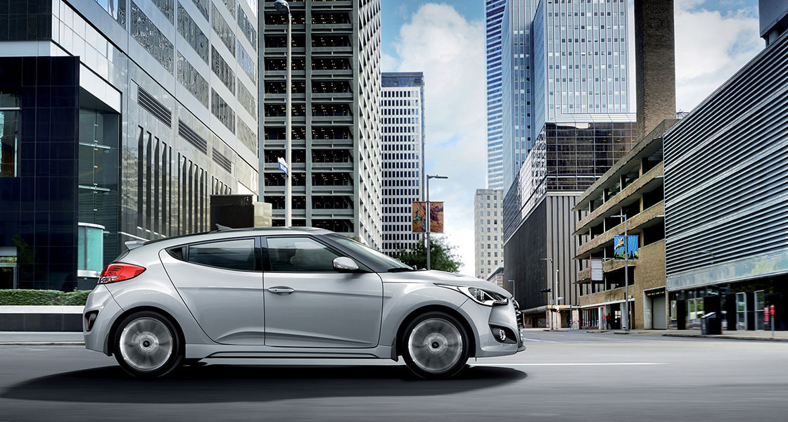 Side view of silver Veloster Turbo driving in the city