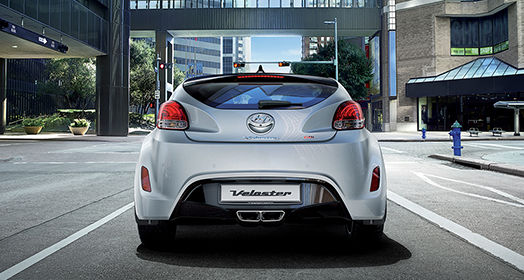 Rear view of white Veloster parked on the road in the city