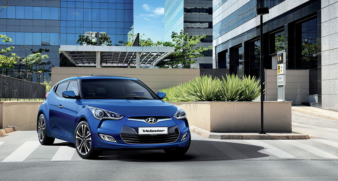 Side front view of blue veloster driving out from the basement parking lot