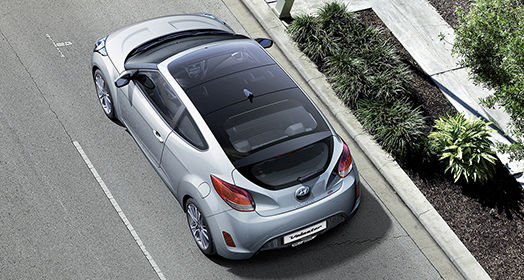 Sky view of silver Veloster from left side rear viewpoint