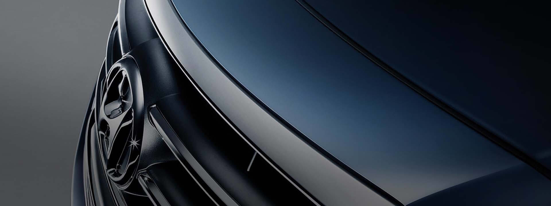 Пристальный взгляд на переднюю часть автомобиля Hyundai с его логотипом и решеткой