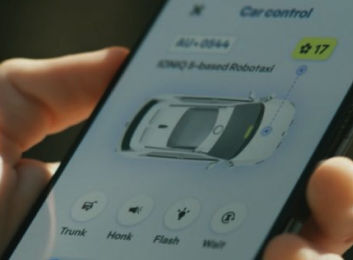 Autonomous driving : A phone screen showing the car controls in an app. There is an image of the robotaxi in bird's-eye view with buttons labeled trunk, honk, flash, and wait.