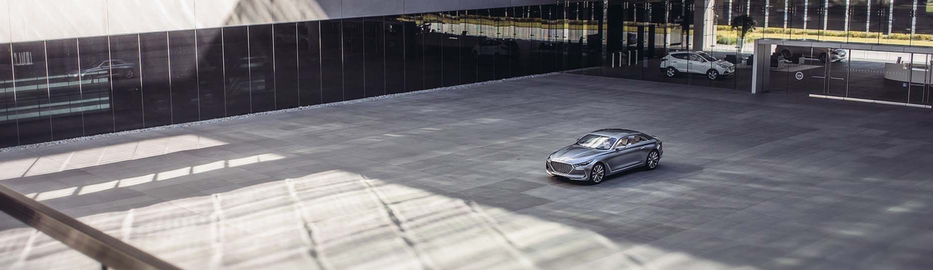 Vista frontal lateral del coche en el cuadrado al lado del edificio.