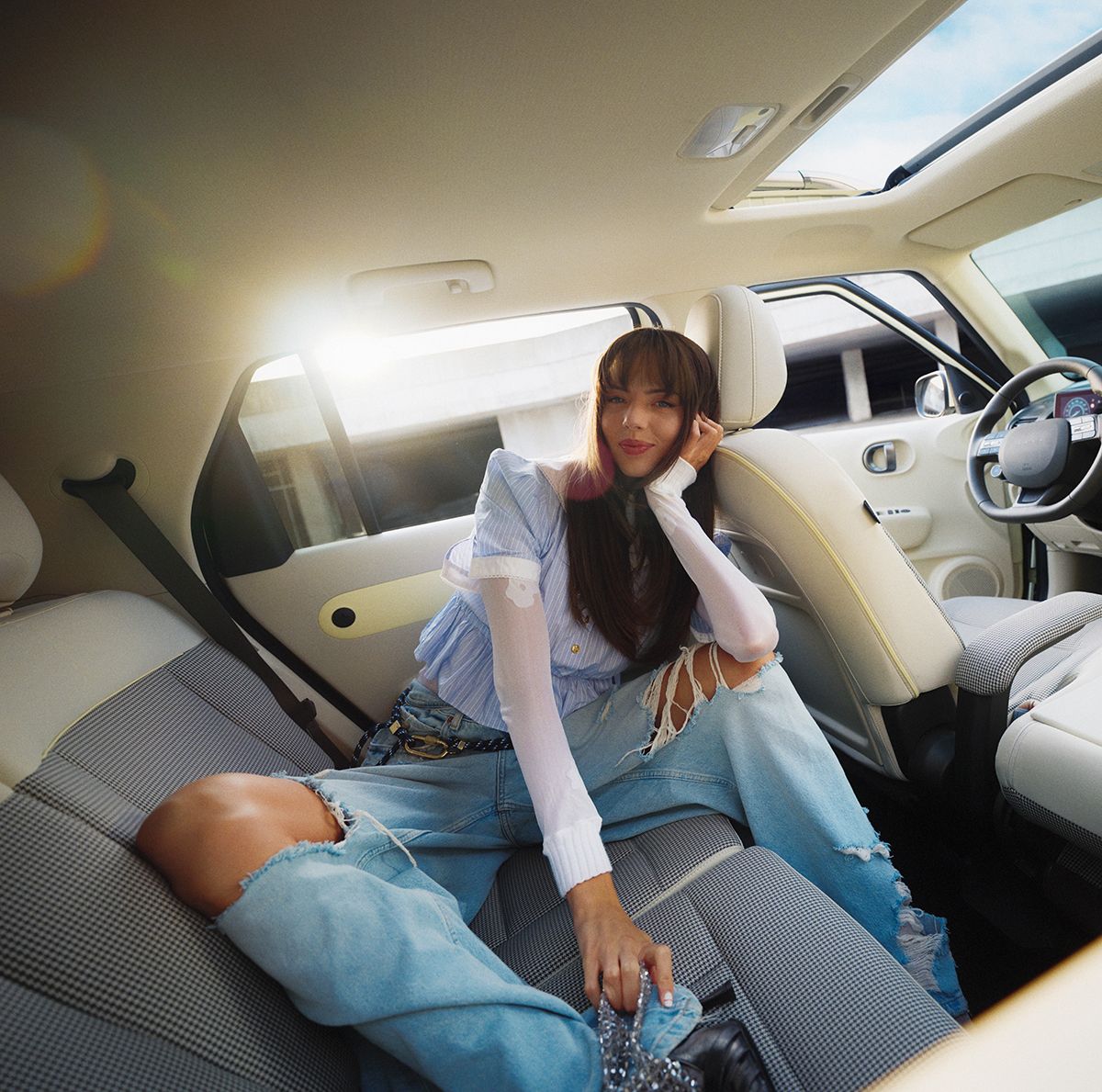 Yeni Hyundai INSTER elektrikli otomobilin geniş arka koltuğunda oturan bir kadın.