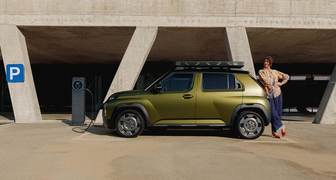 Hyundai INSTER Cross'un arkasına yaslanan bir kadın.