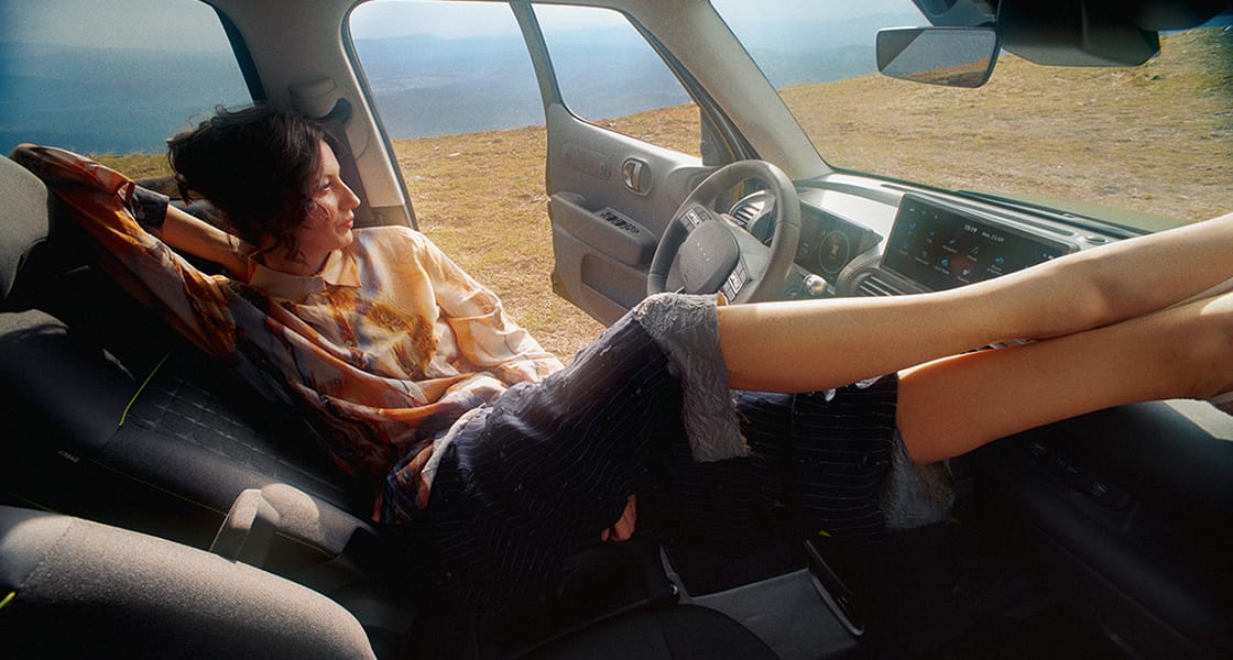 Yeni Hyundai INSTER Cross’un katlanmış halde ön koltuğuna uzanan bir kadın.