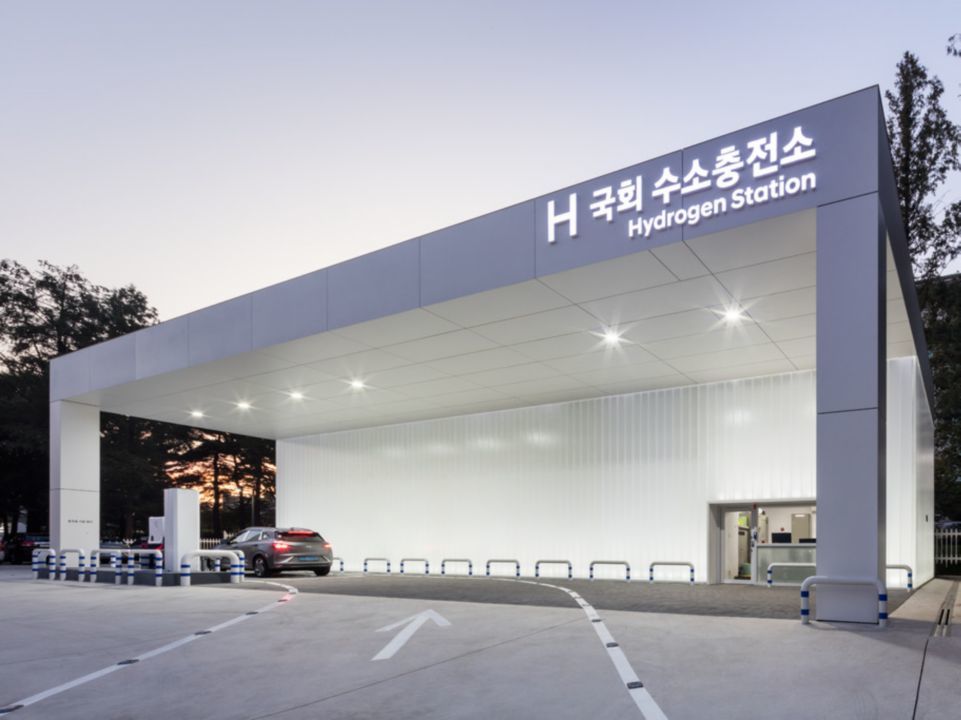 A hydrogen filling station pictured with a Hyundai vehicle driving into it.