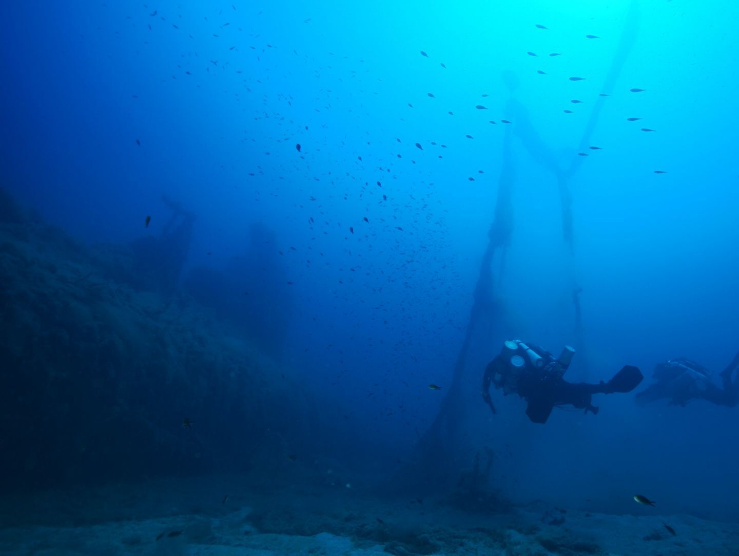 Two divers from Ghost Divers recovering marine debris underwater.