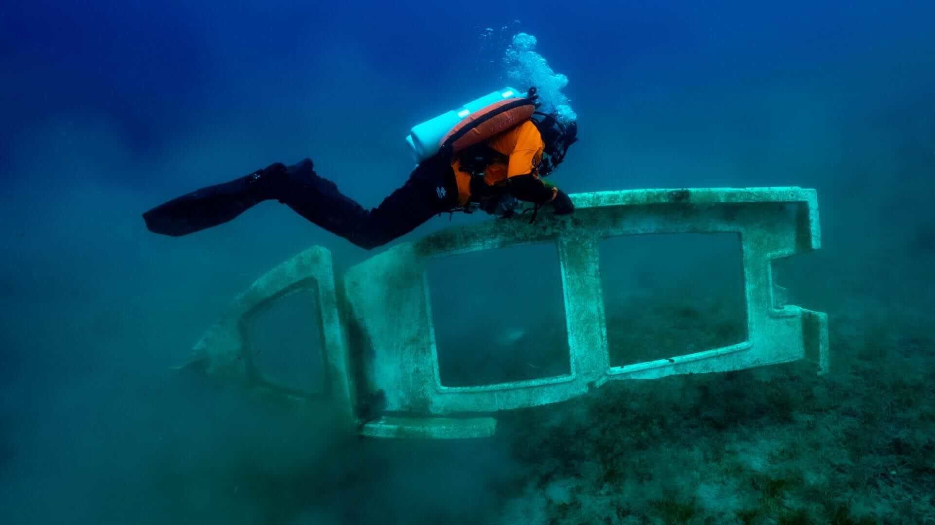 A diver from Ghost Divers recovering marine debris underwater.