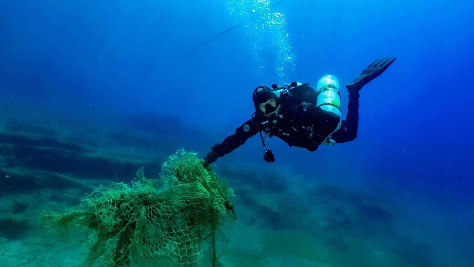A diver from Ghost Divers recovering a lost fishing net underwater.