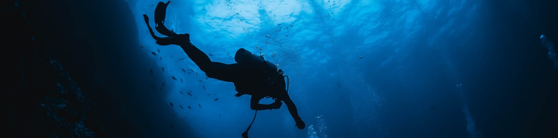 David de Rothschild swimming in the deep blue ocean, photographed from underwater.