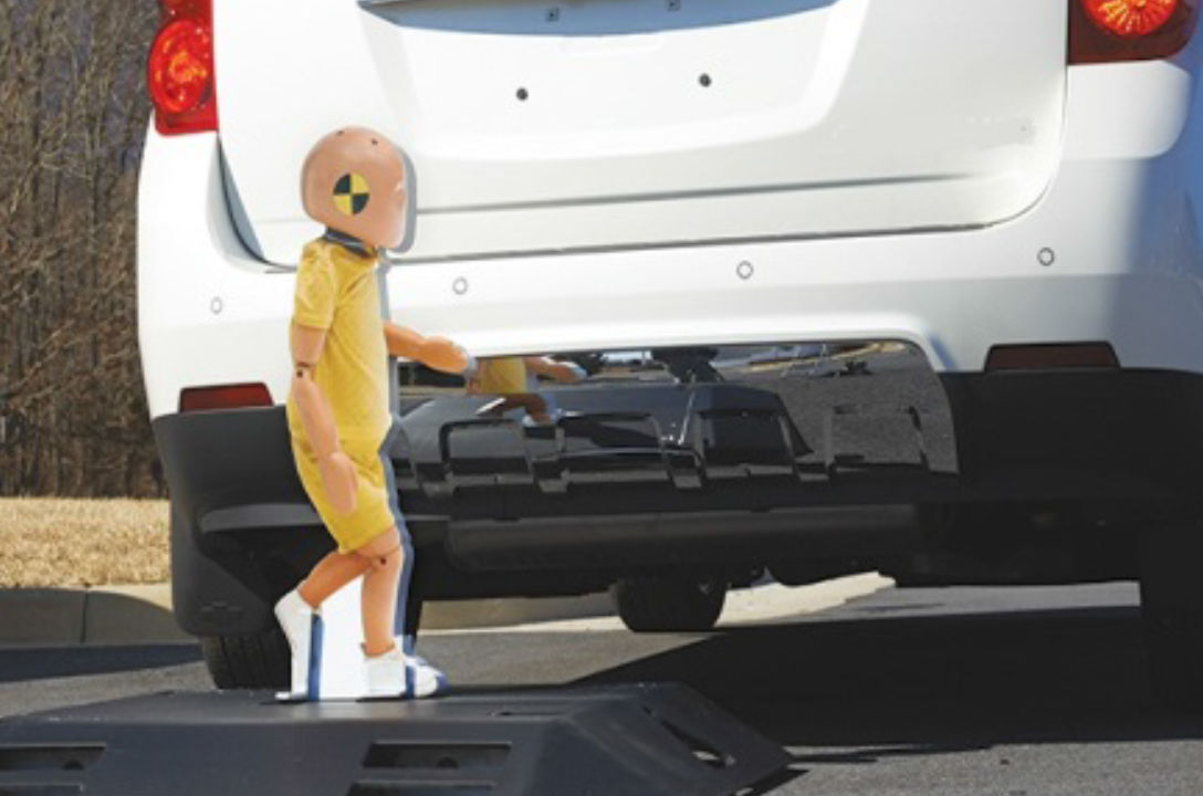Child pedestrian dummy wanders behind a car.