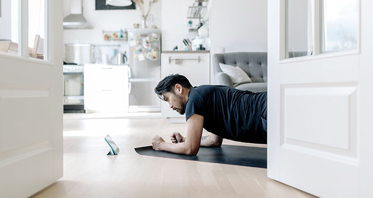 a man exercises in living room