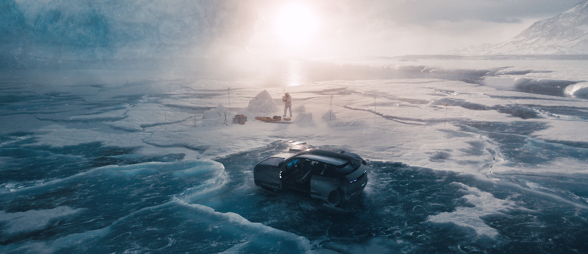 빙하 위에 아이오닉 5가 정차되어 있다 그 주변에 한 사람이 작업을 하고 있다