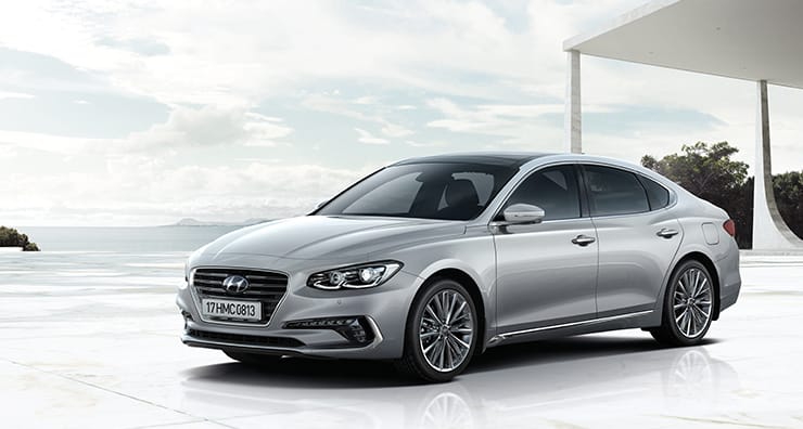 Left side front view of silver Azera parked beach.