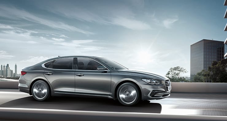 Side view of gray Azera driving on the road.