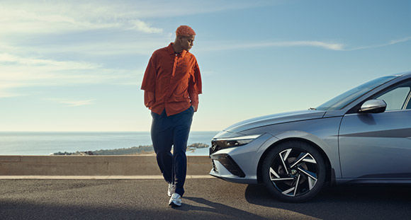 A man is standing in front of the new ELANTRA.