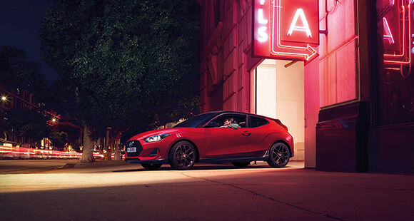 Left side view of red veloster parking