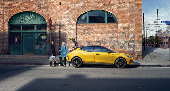 Peoples and side view of yellow veloster parking on the road 