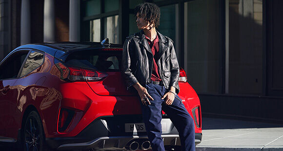 Left side rear view of red veloster parking on the road