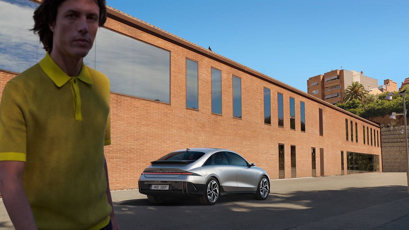 IONIQ 6 rear right quarter view with man in yellow shirts