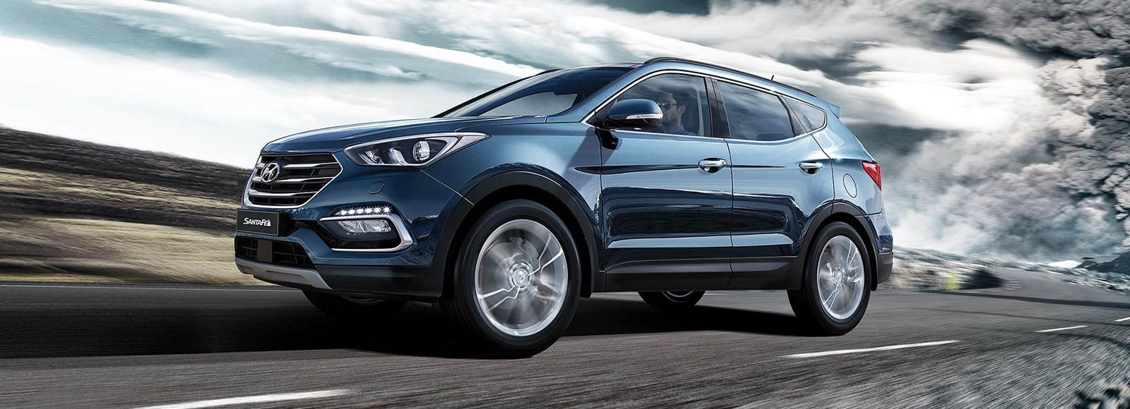 Side view of blue Santa Fe driving on the countryside