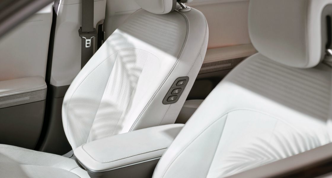 A close-up of the front seats inside the IONIQ 5. The seats are covered in cream colored leather which has been dyed using flaxseed oil instead of oil derived from animal products. 