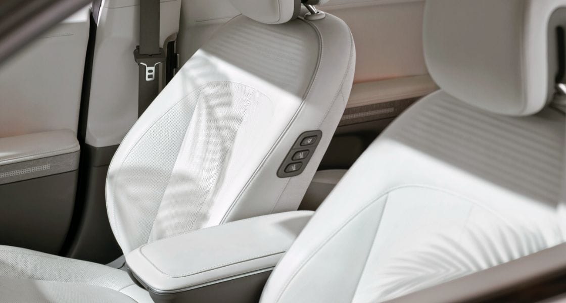 A close-up of the front seats inside the IONIQ 5. The seats are covered in cream colored leather which has been dyed using flaxseed oil instead of oil derived from animal products.
