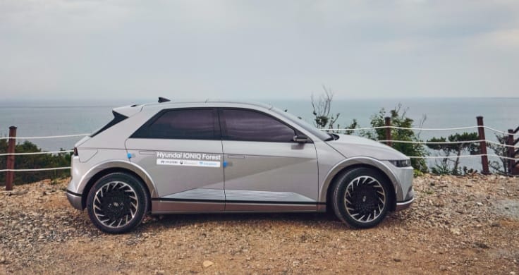 A gray IONIQ 5 shuttle car parked on the edge of the island with the sea behind it.