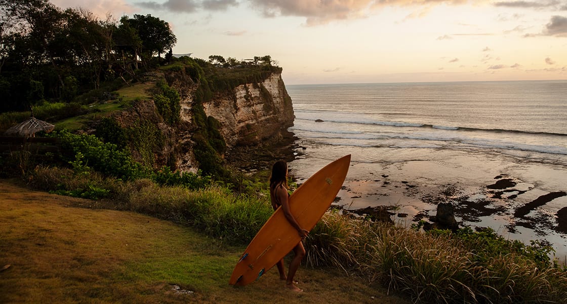 Holding a surfboard on the beach