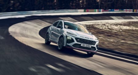 Front view of a KONA N speeding around a corner on a racetrack.