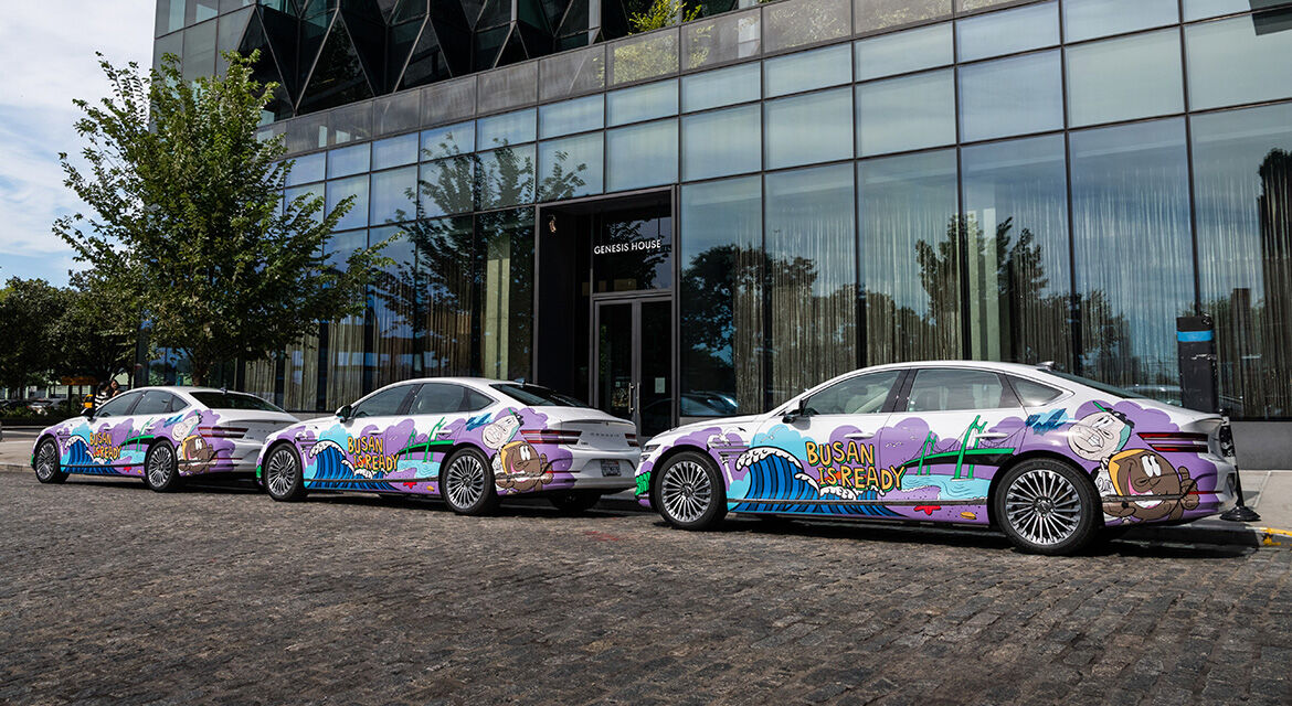 Three Genesis Electrified G80 sedans exhibited at the front of Genesis House New York show graffiti artwork and the slogan to promote Busan's bid to host the 2030 World Expo.