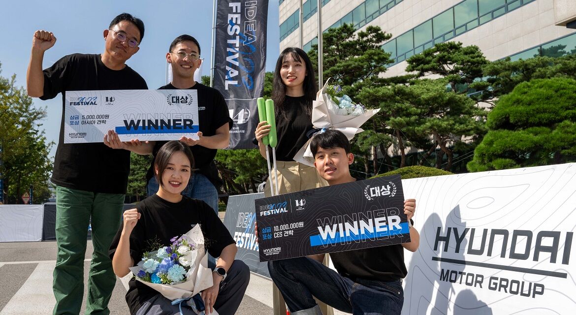 Five members of the Grand Prize Winning Teams - H-sense Team (Production Category), Friendly Brother and Sister Team (Scenario Category), are holding up the prizes and flower bouquets for a photoshoot.