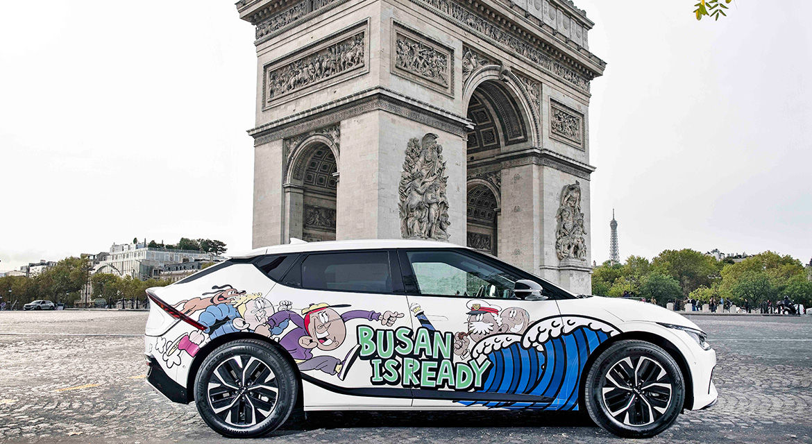 The Kia EV6 art car is exhibited near the Arc de Triomphe de l'Étoile, Paris, showing graffiti artwork and the slogan to promote Busan's bid to host the 2030 World Expo