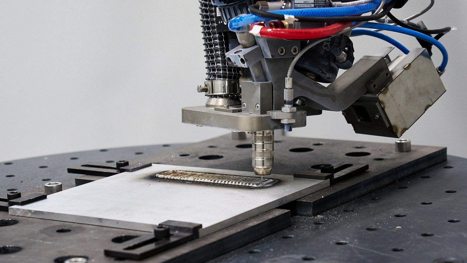 A DED-WAAM (Directed Energy Deposition-Wire Arc Additive Manufacturing) system fabricates a metal component by depositing material layer by layer.