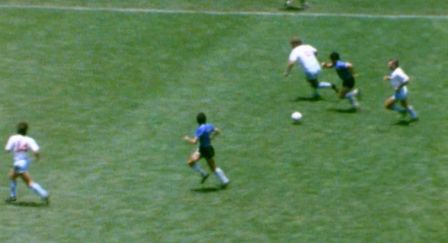 A bird's eye view of a football pitch with two players in blue attacking and three players in white defending.