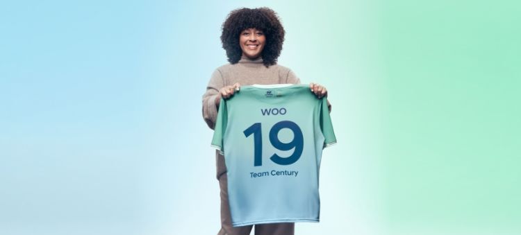 비주얼 스토리텔러이자 Team Century의 멤버인 니키 우가 자신의 이름과 등번호 19번이 적힌 초록색 Team Century 유니폼을 들고 있는 모습입니다.