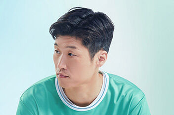 A portrait of male football player and Team Century member Jisung Park looking to his right in front of a blue and green background.