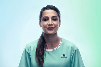 A portrait of Danish football player and Team Century member Nadia Nadim in front of a blue and green background.