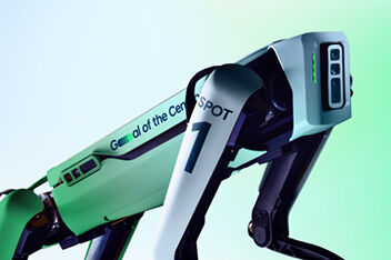 A close-up of the top part of the Spot robot where the robots cameras and sensors are located. The writing ‘Boston Dynamics’ can be seen along one side.