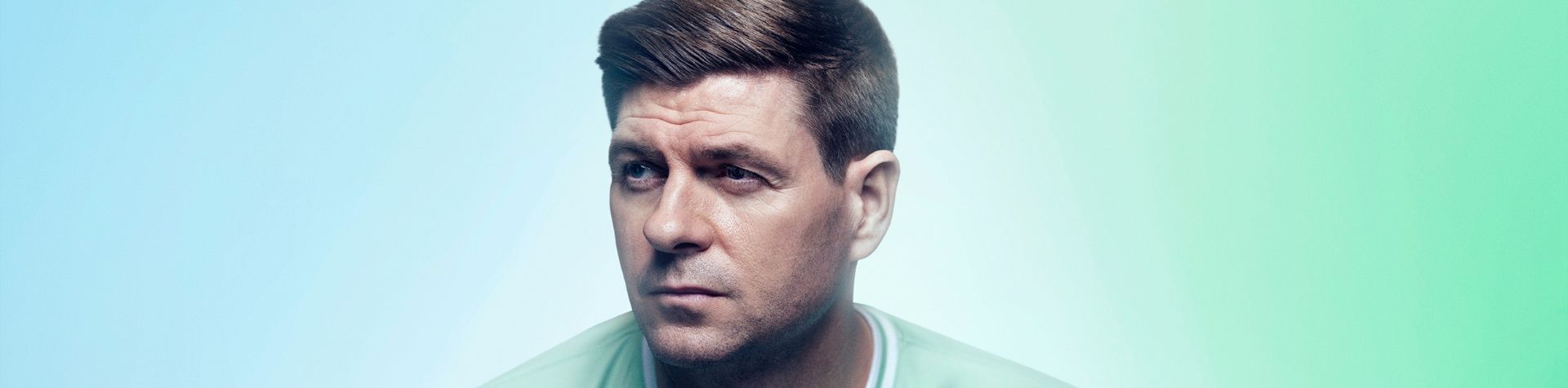 A close-up of Steven Gerrard’s face. He is looking to the left and wearing his Team Century jersey.