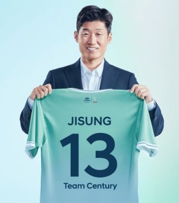 Team Century의 새로운 멤버 박지성이 뒷면에 ​​파란색으로 13번이 새겨진 녹색 Team Century 셔츠를 들고 있습니다.