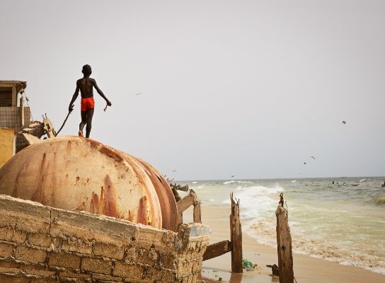 One of Nicky’s photographs depicting a child standing on top of a dome looking into the ocean.