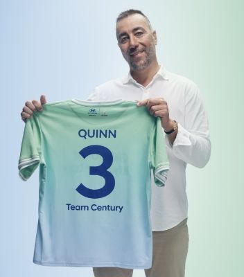 Lorenzo Quinn holding his green and blue Team Century jersey with “Quinn”, “3” and “Team Century” written on the back in dark blue.