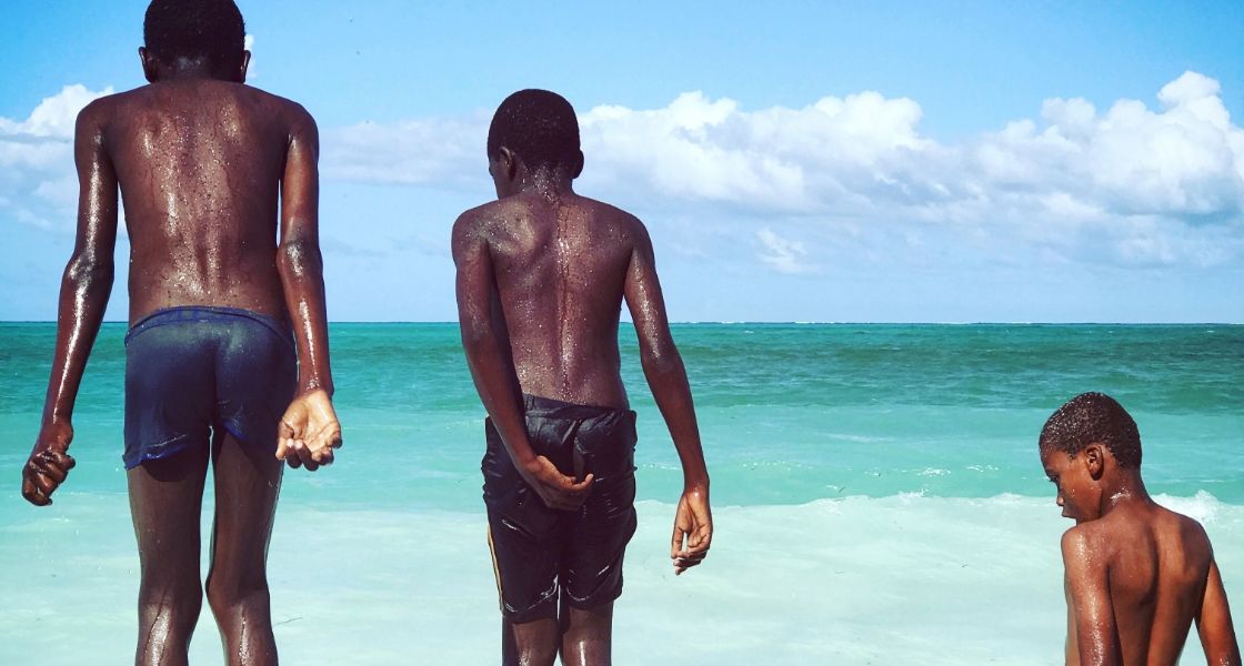 반바지 차림의 세네갈 소년들이 바다에 뛰어들 준비를 마친 채 한 줄로 늘어서 있습니다.
