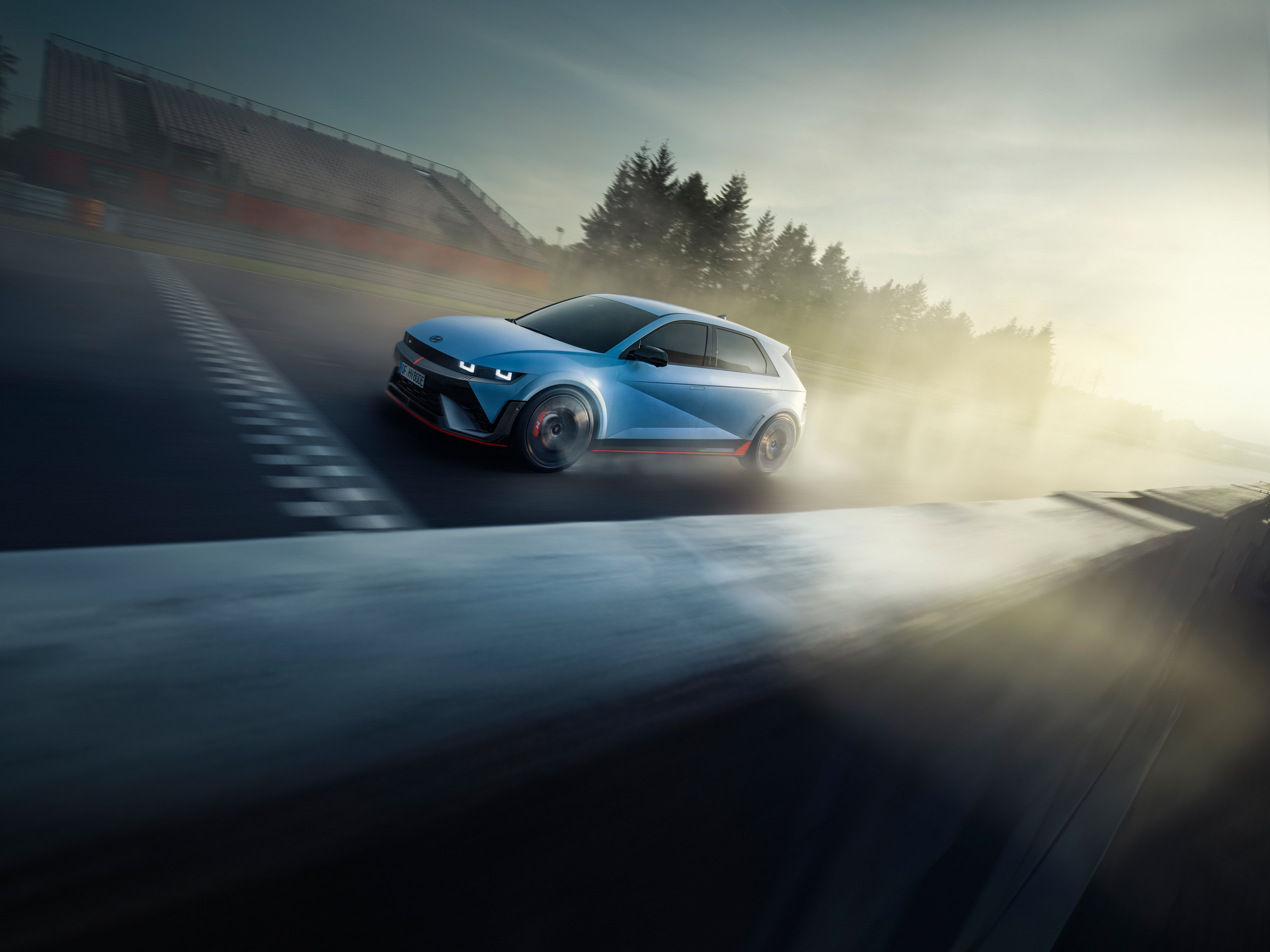 The all-electric Hyundai IONIQ 5 N driving on a race track with some trees. 