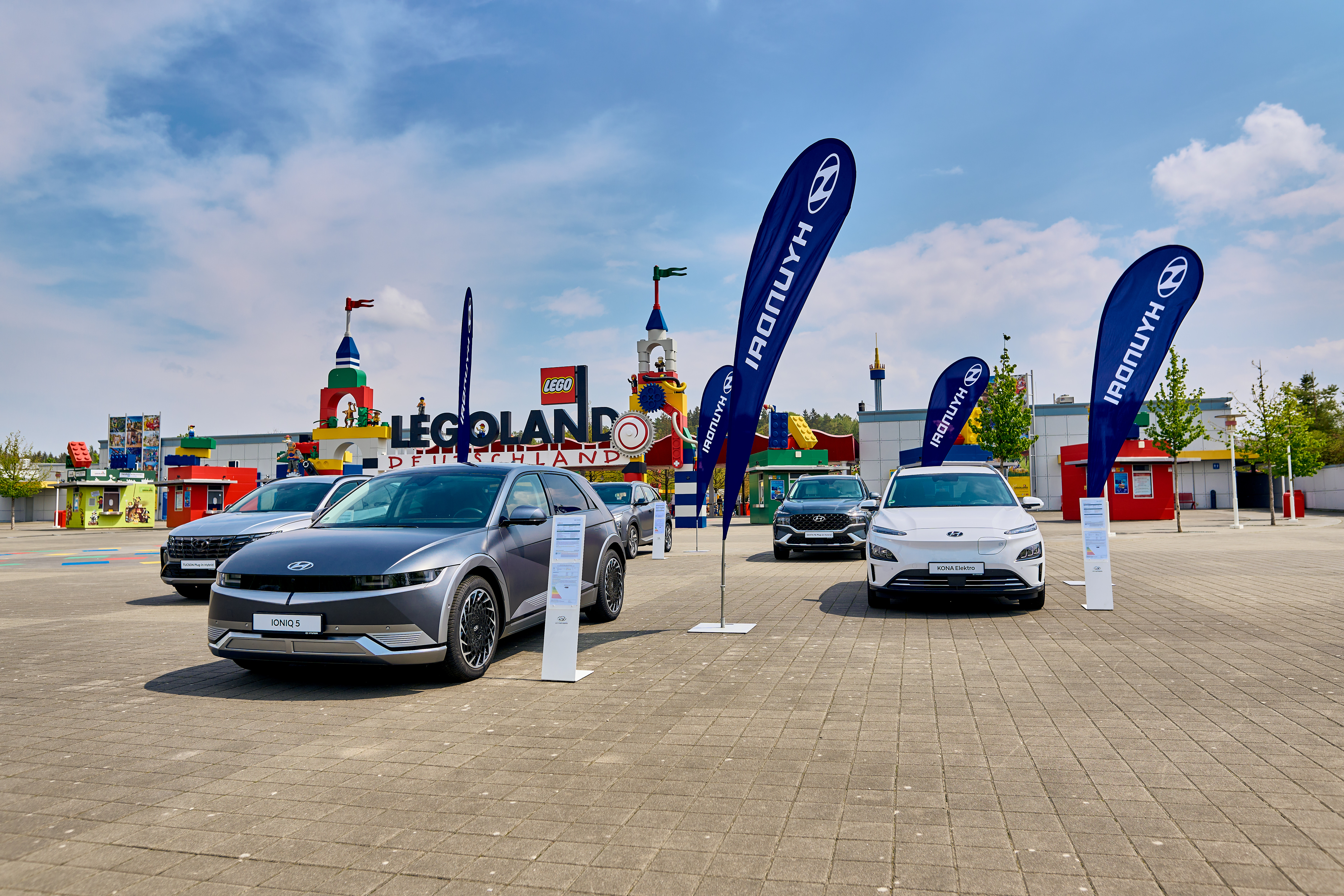 Ein Hyundai IONIQ 5 und weitere Hyundai Modelle vor dem Eingang des LEGOLAND® Deutschland Resort.