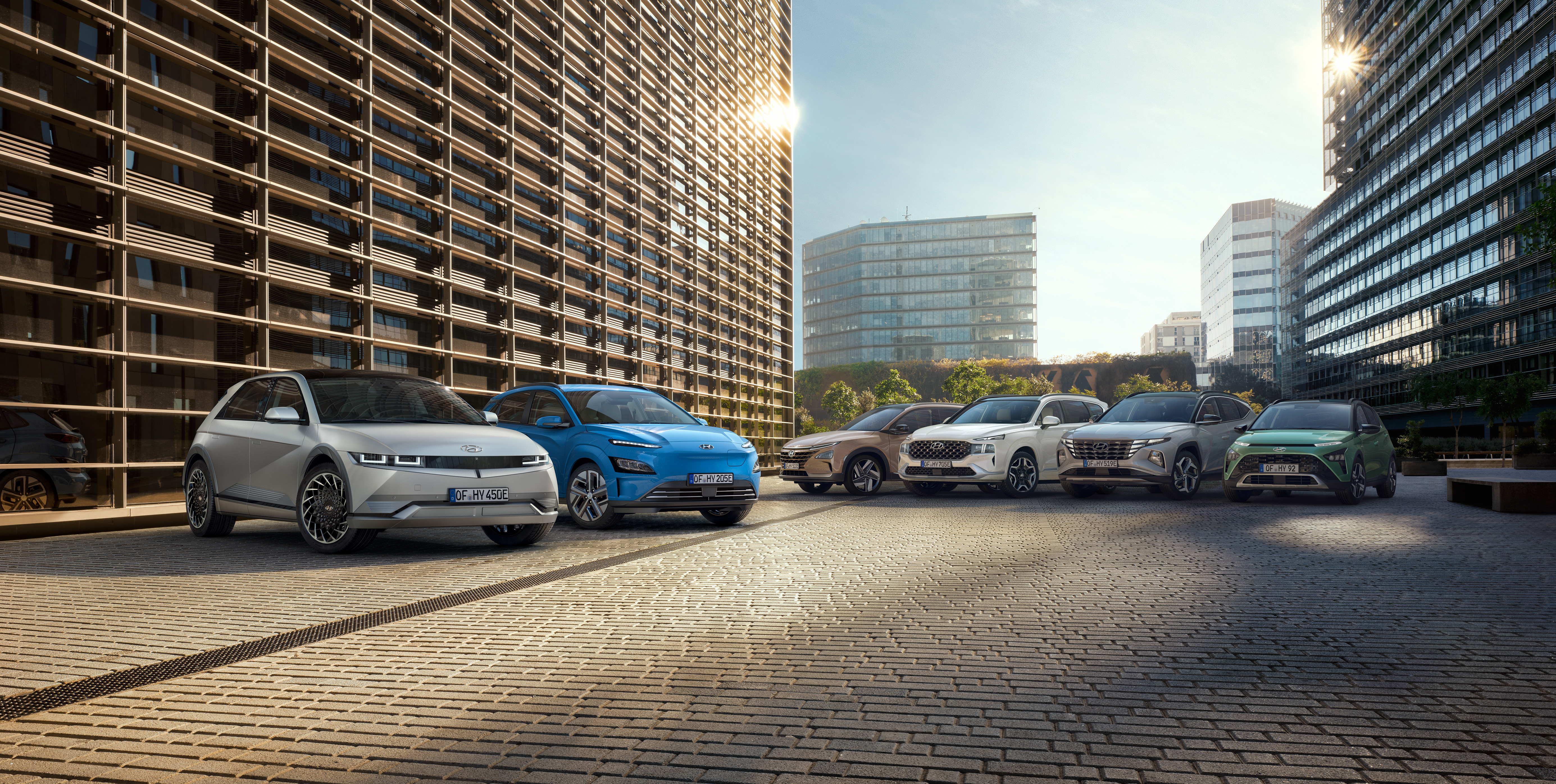 6 Hyundai vehicles parked outside: IONIQ 6, KONA Electric, NEXUS. SANTA FE, TUCSON, BAYON.