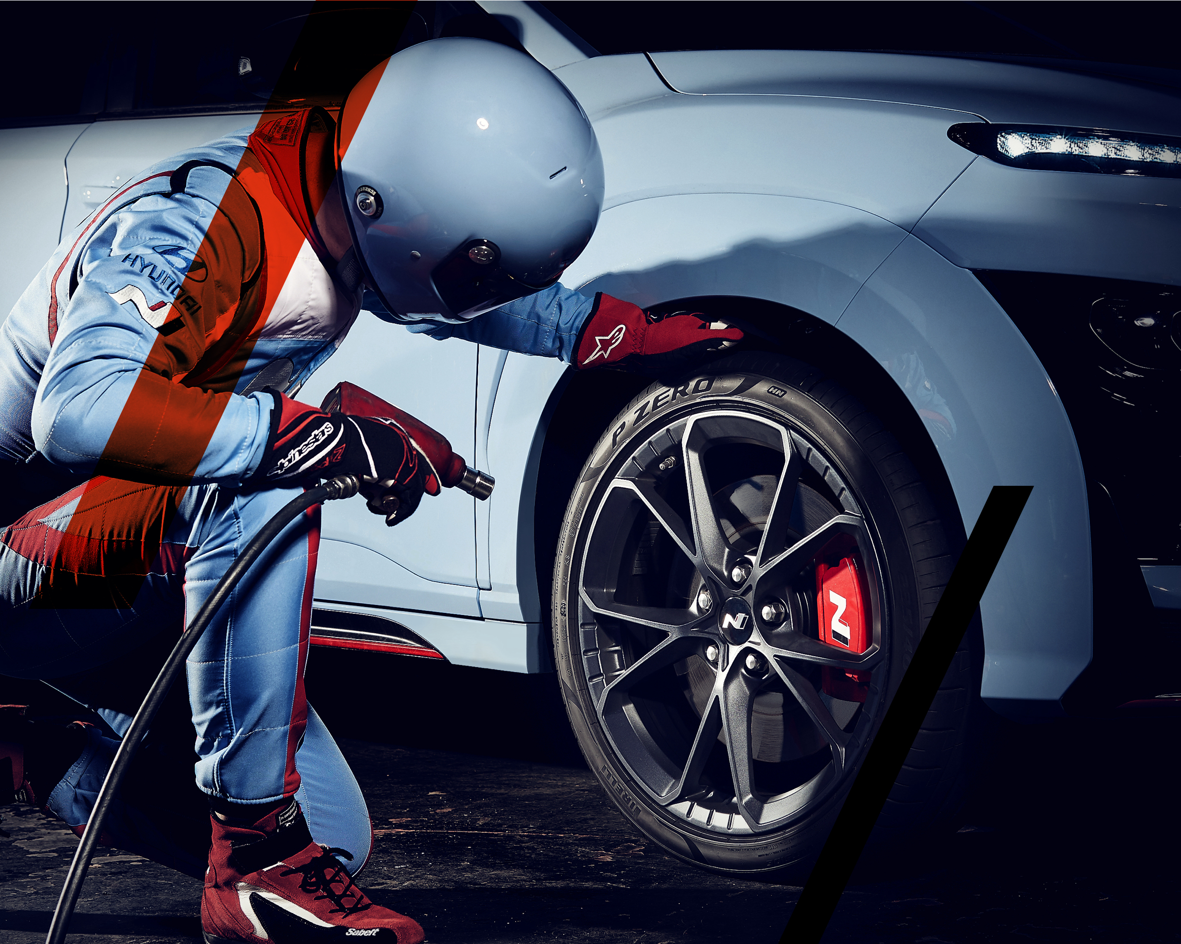 Hyundai N Man kneeling next to a KONA N high-performance SUV touching the P Zero tyres.